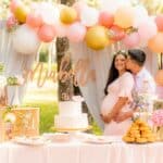 photo of couple with pregnant woman kissing with baby shower decorations for diaper baby shoewr